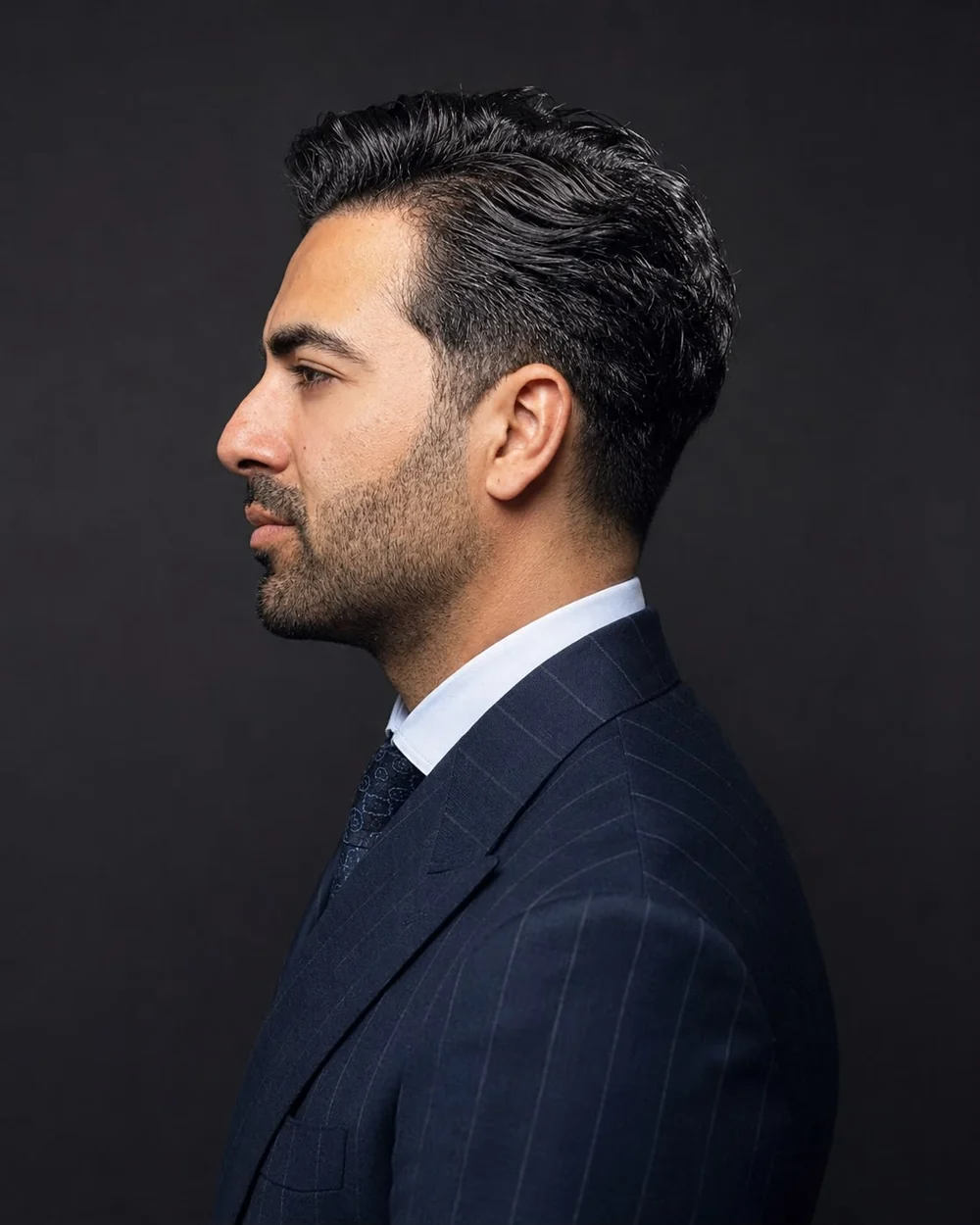 Mohammad Ali Shahbaz, co-founder of Claves House, in profile wearing a navy pinstripe suit.